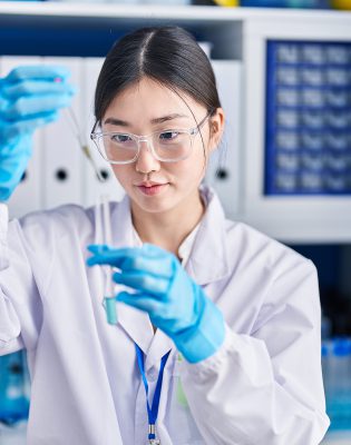 Chinese woman scientist pouring liquid on test tube at laboratory Chinese woman scientist pouring liquid on test tube at laboratory